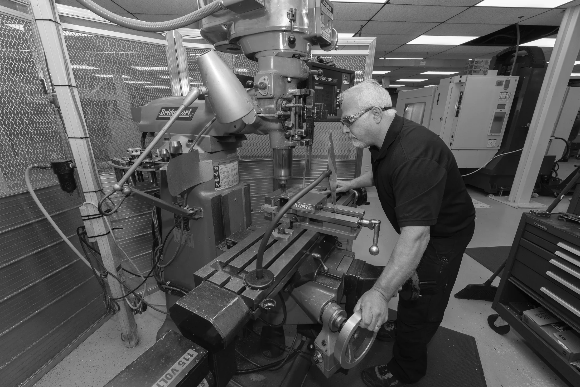 An engineering technician operating a milling machine in a fabrication workshop